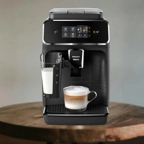 A imagem é composta por uma mesa de madeira e em cima dessa mesa há uma cafeteira de modelo lattego 2200 da marca Philips Walita de cor preta um copo com capuccino dentro